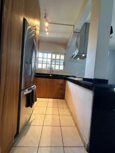 a kitchen with a refrigerator and a tile floor at Casita Océano in La Paz +12 photos