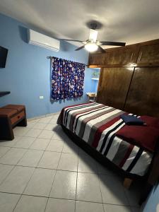 a bedroom with a bed and a ceiling fan at Casita Océano in La Paz
