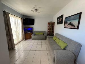 a living room with a couch and a tv at Casita Océano in La Paz