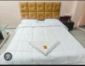 a large white bed with a white blanket on it at Hotel Nest in Nagda