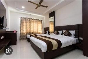 a bedroom with a large bed and a ceiling fan at Hotel Nest in Nagda