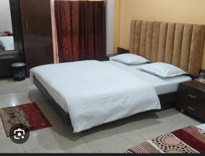 a bedroom with a large bed with white sheets and pillows at Hotel Nest in Nagda