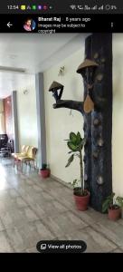 a room with a tree with a hat on it at Hotel Nest in Nagda
