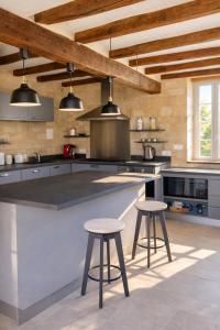 a kitchen with a large counter with two stools at La longère du golf in Verneuil-sur-Indre