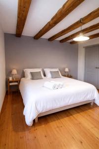 a bedroom with a large white bed with two pillows at La longère du golf in Verneuil-sur-Indre