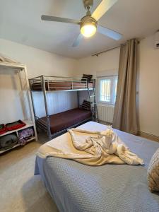 a bedroom with a bunk bed and a ceiling fan at Casa Pumba in San Martín de la Vega