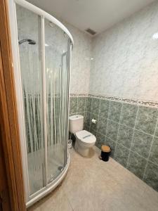 a bathroom with a toilet and a glass shower at Casa Pumba in San Martín de la Vega