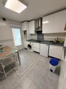 a kitchen with white cabinets and a table in it at Casa Pumba in San Martín de la Vega