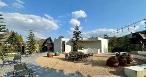 a patio with chairs and tables and a building at Khunkhao Paradise Khao Yai in Ban Rai Khlong Sai