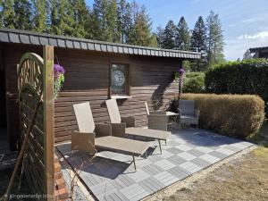 a wooden shed with chairs and a table at Ferienhaus Herzkate in Bremervörde
