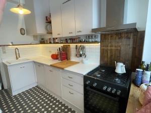 a kitchen with white cabinets and a black stove at Spacious Home in Brussels in Brussels
