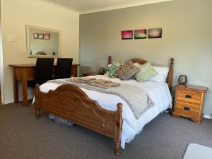 a bedroom with a bed with a table and a desk at Hampden Heaven in Hampden