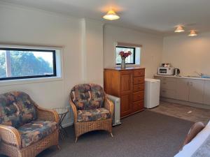 a living room with two chairs and a kitchen at Hampden Heaven in Hampden
