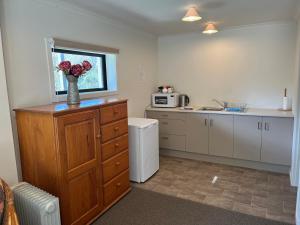 a kitchen with a vase of flowers on a counter at Hampden Heaven in Hampden +12 photos