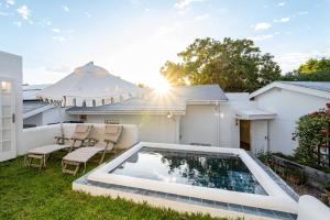 a backyard with a swimming pool and an umbrella at Long Story Guest House in Plettenberg Bay