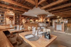 a large room with wooden ceilings and a table with wine glasses at Gaarten Hotel Benessere Spa by Kleos Group Collection in Gallio