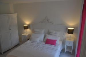 a bedroom with a white bed with a pink pillow at Caterina.C B&B in Val Della Torre