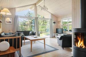 a living room with a fireplace and a couch at 30816-Ulfborg-Oster-Skovvej-67 in Ulfborg