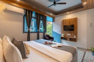ein Schlafzimmer mit Bett, Fernseher und Fenster in der Unterkunft ZoukStayz in Rishikesh