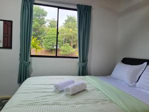 a bedroom with a bed with two towels on it at Mutodon Green in Kuala Penyu
