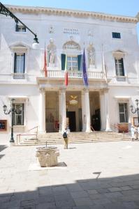 een wit gebouw met vlaggen ervoor bij Casa Alba in Venetië
