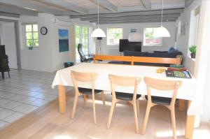 a dining room with a white table and chairs at 20132-Ulfborg-Tyttebaervej-19 in Ulfborg