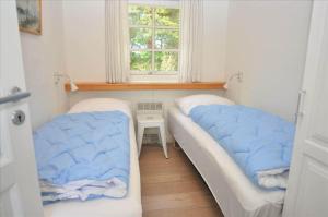 two beds in a small room with a window at 20132-Ulfborg-Tyttebaervej-19 in Ulfborg