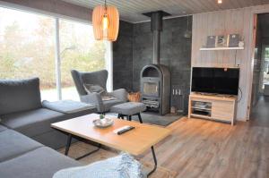 a living room with a couch and a fireplace at 30171-Ulfborg-Snerlevej-492 in Ulfborg