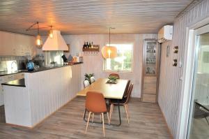 a kitchen with a table and chairs in a room at 30171-Ulfborg-Snerlevej-492 in Ulfborg