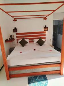 a bedroom with a large bed with a wooden headboard at Robert Ayurveda Villa in Bentota