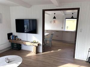 a living room with a tv and a table and a mirror at 70240-Ulfborg-Vesterhavsgade-12 in Ulfborg