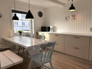 a kitchen with a table and chairs in a kitchen at 70240-Ulfborg-Vesterhavsgade-12 in Ulfborg