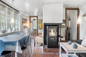 a living room with a fireplace and a dining table at 30327-Ulfborg-Grastensborgvej-38 in Ulfborg +13 photos