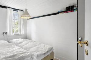 a bedroom with a white bed and a window at 30327-Ulfborg-Grastensborgvej-38 in Ulfborg
