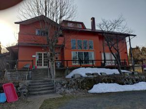 a red house with snow in front of it at ペンション自給自足 in Miyazu