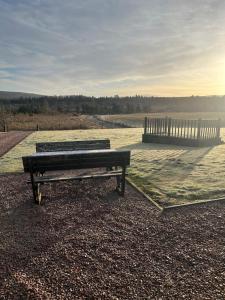 a park bench sitting in front of a body of water at Ardbrae Apartments in Daviot