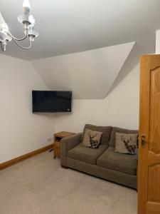 a living room with a couch and a flat screen tv at Ardbrae Apartments in Daviot