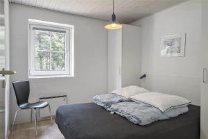 a bedroom with a bed and a chair and a window at 10607-Ulfborg-Gaffelbjergvej-38 in Ulfborg +19 photos
