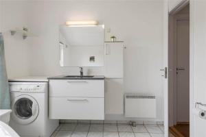 a white kitchen with a washing machine and a washer at 20733-Ulfborg-Sortebaervej-4 in Ulfborg