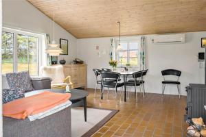 a living room with a couch and a table and chairs at 20733-Ulfborg-Sortebaervej-4 in Ulfborg +14 photos