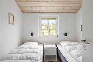 two beds in a room with a window at 20733-Ulfborg-Sortebaervej-4 in Ulfborg