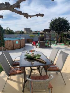 a table and chairs with a playground in the background at Casa Enric , con zona infantil, piscina y parking privado in Deltebre