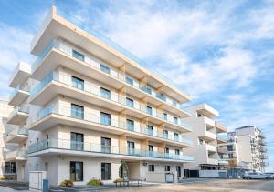 a white apartment building with a sky at ASTI Residence Aparthotel in Năvodari