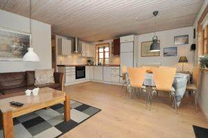 a living room and kitchen with a table and chairs at 80011-Vemb-Harpotvej-84 in Vemb