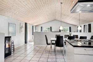 a kitchen and dining room with a table and a fireplace at 10878-Ulfborg-Graemvej-31 in Ulfborg