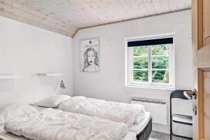 a white bedroom with a bed and a window at 10878-Ulfborg-Graemvej-31 in Ulfborg