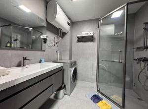 a bathroom with a shower and a washing machine at 梦息民宿 in Guyuan