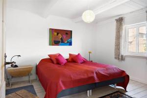 a bedroom with a red bed with pink pillows at 20033-Ulfborg-Vesterhavsvej-15 in Ulfborg