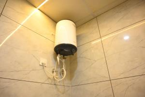 a white light on the wall of a bathroom at SHIVAAY GARDEN in Kannauj
