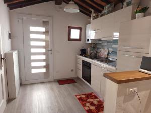 a kitchen with white cabinets and a door at Casina Luce in Stiava